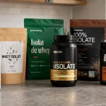 Plusieurs pots de whey protéine et un shaker sur un plan de travail